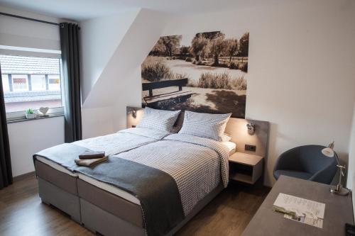 Pension Dalinghaus في Vörden: غرفة نوم بسرير مع صورة على الحائط