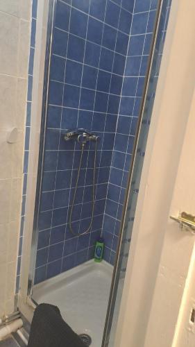 a bathroom with a shower with blue tiles at CENTRaL Gem 3Bdr, Balcony &Views in Gibraltar