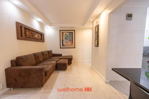 ein Wohnzimmer mit einer braunen Couch in einem Zimmer in der Unterkunft Apto Praia das Pitangueiras com Piscina aquecida in Guarujá