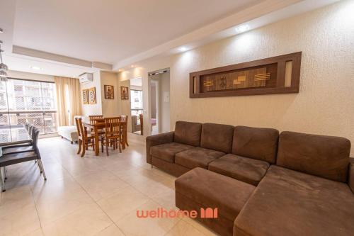 ein Wohnzimmer mit Couch und ein Esszimmer in der Unterkunft Apto Praia das Pitangueiras com Piscina aquecida in Guarujá