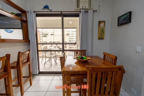 グアルジャにあるApartamento em Guarujá próximo ao Shopping La Plageの木製のテーブルと椅子のあるダイニングルーム