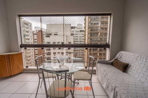 グアルジャにあるApartamento em Guarujá próximo ao Shopping La Plageの窓のあるリビングルーム(テーブル、椅子付)