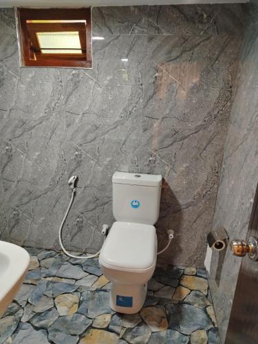 a bathroom with a toilet and a sink at New Kethhala Hotel 