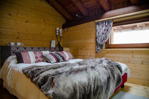 um quarto com uma cama num chalé de madeira em Au Rascard em Brusson