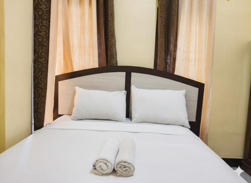 a bed with two towels sitting on top of it at FIFAWIND HOTEL in Labuan Bajo