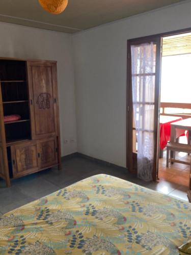 a bedroom with a bed and a sliding glass door at Gîte LEUCALYPTUS in Saint-Paul