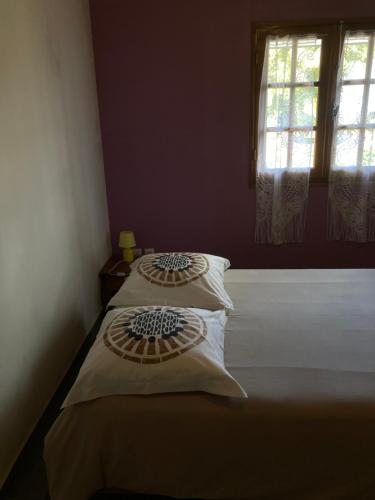 a bedroom with a bed with white sheets and a window at Gîte LEUCALYPTUS in Saint-Paul