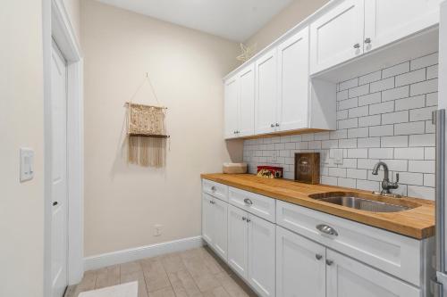 a kitchen with white cabinets and a sink at Spanish Charm 4br Guest House Private Yard in West Palm Beach