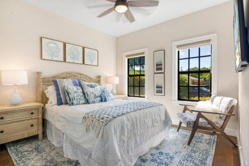a bedroom with a bed and a chair and windows at Spanish Charm 4br Guest House Private Yard in West Palm Beach
