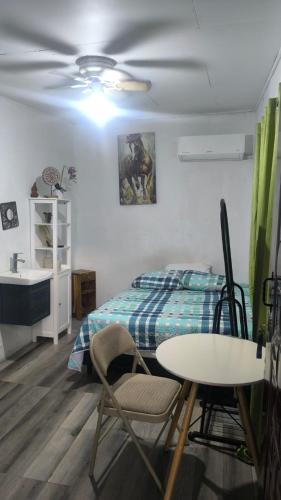 a bedroom with a bed and a table and chairs at LA CASA DE DON MATILDE in San Pedro Sula