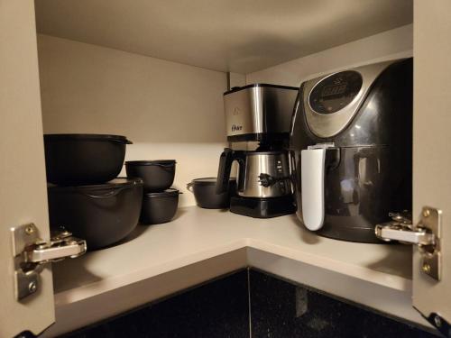 a kitchen counter with a coffee pot and a coffeemaker at Flat Serra fácil acesso a Savassi l Cozinha Completa l Novo l Área Nobre de BH in Belo Horizonte