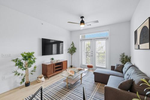 a living room with a couch and a table at 412 Stylish 2B2B Resort Style Pool & Gym, Golf Simulator, 7M to Dickies Stadium, 15M to AT&T stadium in Fort Worth