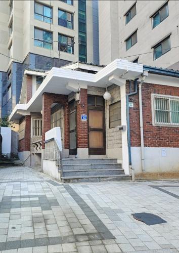 a building with a porch and stairs in front of a building at FLYING Stay 플라잉스테이 in Seoul