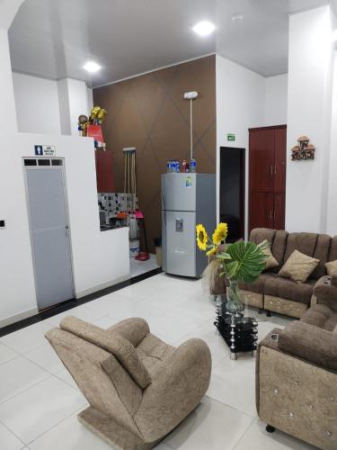 a living room with two couches and a kitchen at Hotel Paris Mirador in Garzón