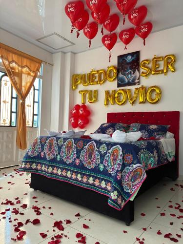 a bedroom with a bed with red hearts and balloons at Hotel Paris Mirador in Garzón