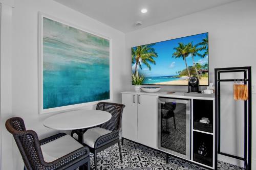 a dining room with a table and chairs and a painting at Seaside at Anna Maria Island Inn in Bradenton Beach