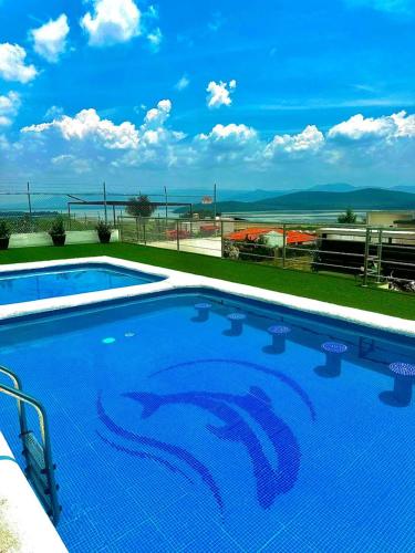 a blue swimming pool with a view of the ocean at Hotel Gesa in Villa Corona