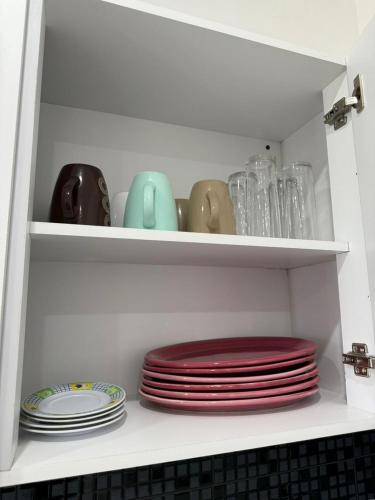 a white cabinet with plates and dishes in it at Hotel Gesa in Villa Corona