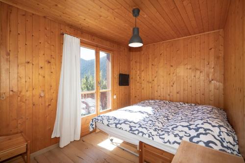 sypialnia z łóżkiem i oknem w obiekcie Panorama Chalet Ovronnaz 180 View 2BA 10 pax w mieście Ovronnaz