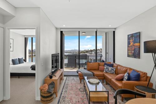 a living room with a couch and a room with a bed at River View 1BR with Amazing Rooftop Pool and Parking in Brisbane