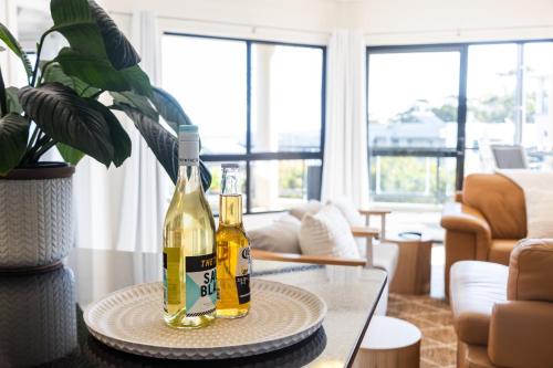two bottles of wine on a table in a living room at Spectacular Sol y Mar @ Nambucca Heads in Nambucca Heads