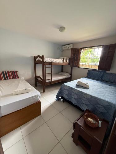 a bedroom with two beds and a bunk bed at Meu Aconchego in Tamandaré