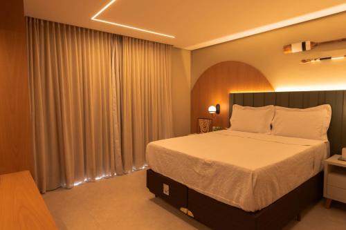 a bedroom with a large bed and a large window at Casa Varandas Morro de São Paulo in Cayru