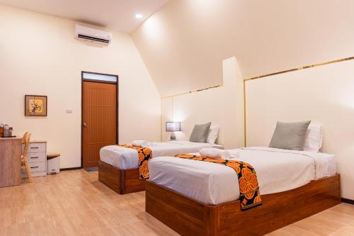 two beds in a room with white walls at Furusato Matcha Cafe & Ryokan Chiangmai in Ban Pang Champi