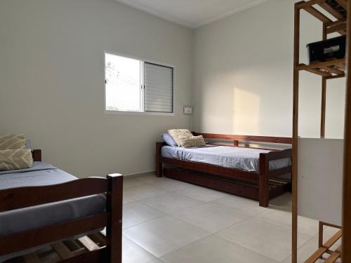 Un dormitorio con dos camas y una ventana. en Conforto a 8min da Canção Nova com Garagem, en Cachoeira Paulista