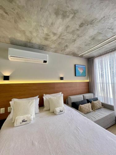 ein Schlafzimmer mit einem großen Bett und einer Couch in der Unterkunft Setai Yacth, Flat para até 03 pessoas a beira mar do Cabo Branco in João Pessoa