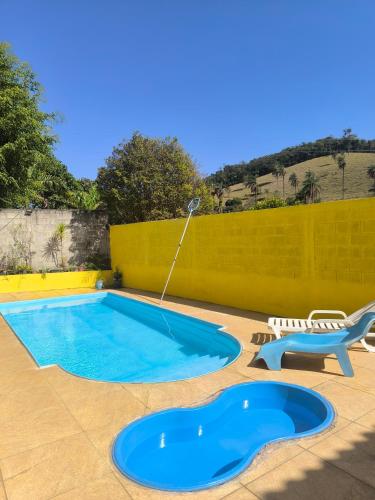 a swimming pool with a water hose in a yard at Sítio vida boa - Jambreiro in Itabira
