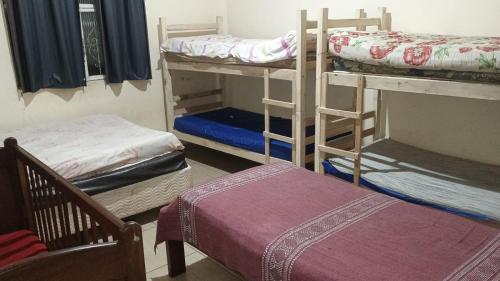 a room with four bunk beds and a chair at Sítio vida boa - Jambreiro in Itabira