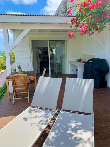 a patio with a table and chairs on a deck at SUNSEEKER SXM - Luxury Guest House 4 stars - Amazing Sea View Pinel - Tintamarre in Orient Bay