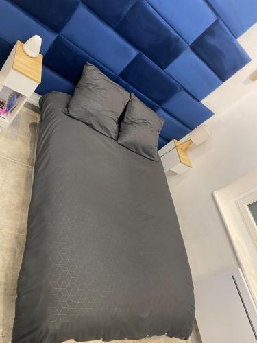 a bed in a room with a blue wall at Studio Jacuzzi in Montargis centre in Montargis