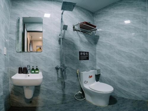 a bathroom with a shower and a toilet and a sink at Napoli Hostel Cat Ba in Cat Ba