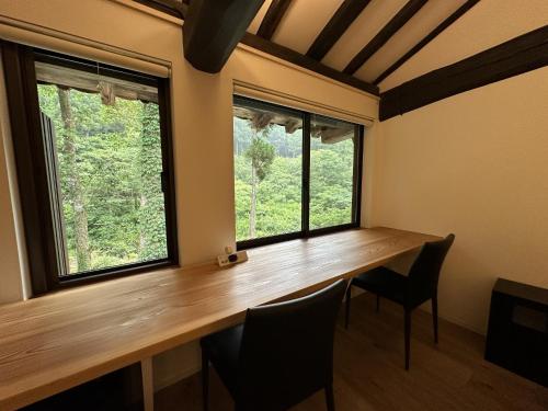a room with a wooden table and two windows at Shimosato - Vacation STAY 77681v in Komatsu