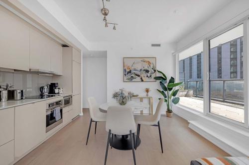 a kitchen and dining room with a table and chairs at Prime 2BR Condo with Massive Patio & Parking in Toronto