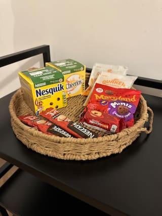 a basket filled with snacks on a table at Luxury Apartment in Milton Keynes with Netflix in Broughton