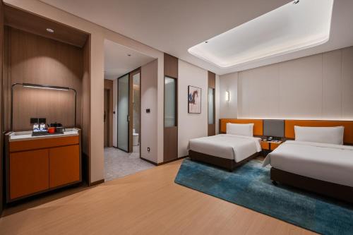 Una habitación de hotel con dos camas y un baño. en Novotel Hangzhou Xintiandi, en Hangzhou