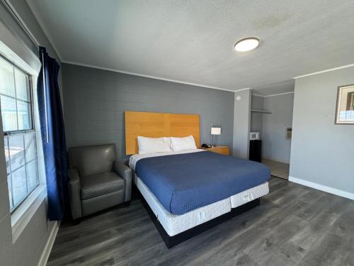 a bedroom with a bed and a chair at Budget Inn Port Lavaca in Port Lavaca