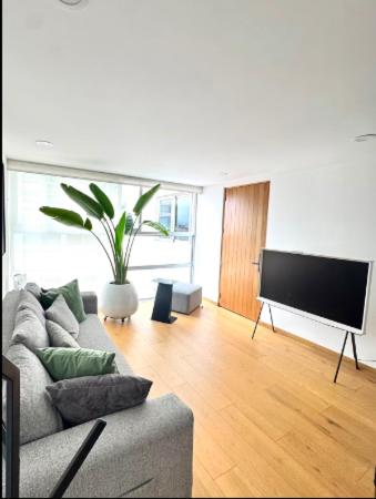 a living room with a couch and a flat screen tv at depto con alberca zona condesa in Mexico City