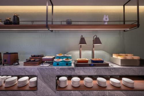 a buffet line with plates and other food on display at Novotel Hangzhou Xintiandi in Hangzhou