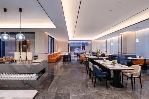 a restaurant with tables and chairs and a bar at Novotel Hangzhou Xintiandi in Hangzhou