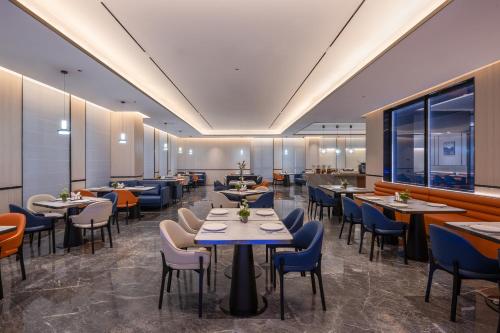 a restaurant with tables and chairs in a room at Novotel Hangzhou Xintiandi in Hangzhou