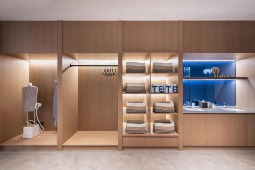 Un baño con lavabo y estante con toallas. en Novotel Hangzhou Xintiandi, en Hangzhou