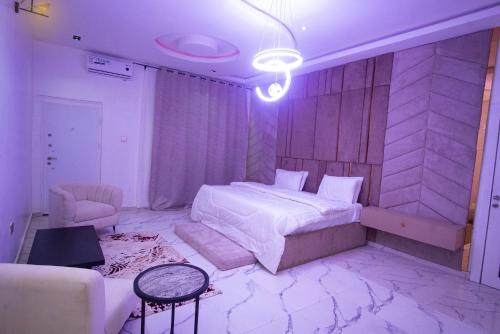 a bedroom with a bed and a chair in it at Lily Luxury Home Shortlet Apartments 