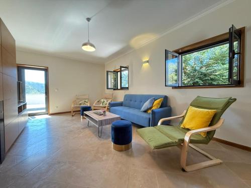 a living room with a blue couch and a table at Casa Bagulho - Cabril, Gerês in Montalegre