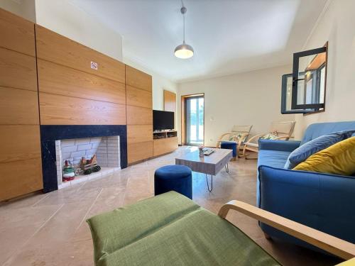 a living room with a blue couch and a fireplace at Casa Bagulho - Cabril, Gerês in Montalegre