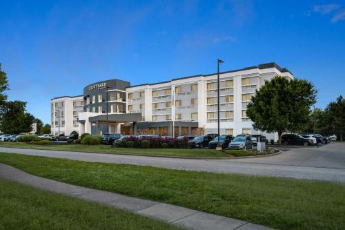 a large white building with cars parked in a parking lot at Courtyard by Marriott Evansville East in Evansville