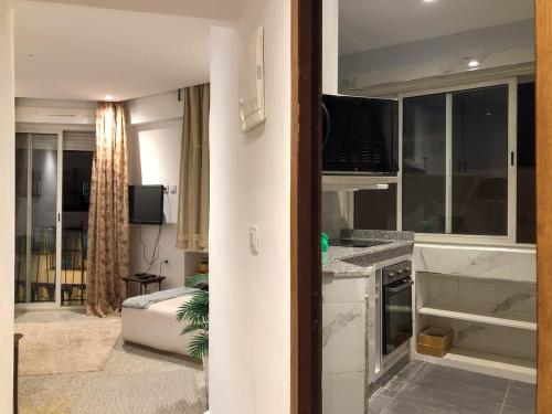 Una cocina y una sala de estar con una computadora portátil en el mostrador. en Seamless Travel - Steps from Train Station & Medina Gate, en Rabat